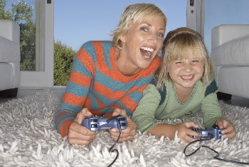 girl playing video game with mother